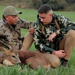 Cazadores mostrando munición Hornady junto a un corzo abatido en montaña en Trofeo caza y conservación